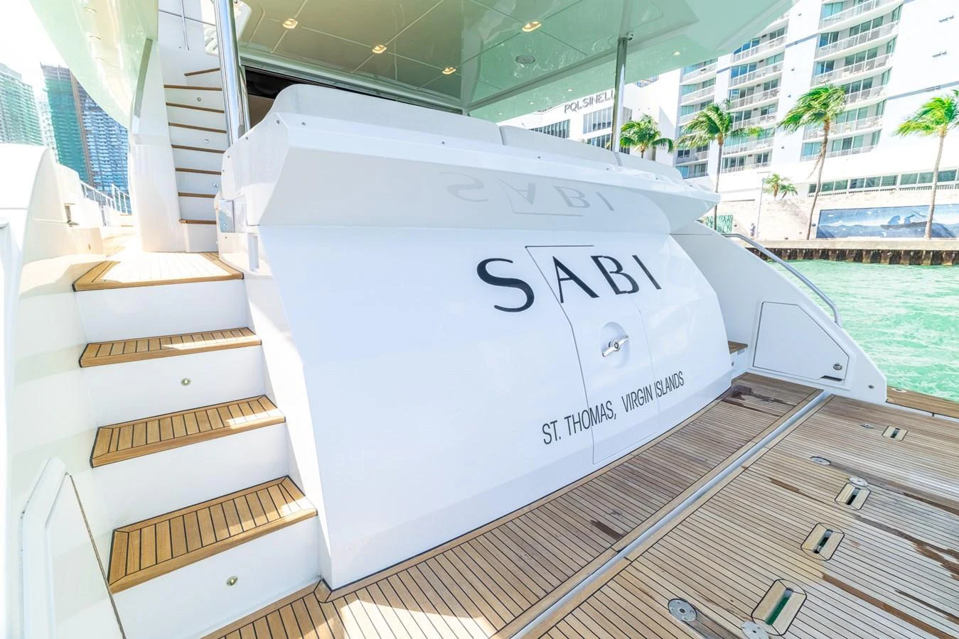 The aft deck of the yacht features elegant teak flooring and a sleek design, perfect for enjoying waterfront views. aboard SABI Yacht for Sale
