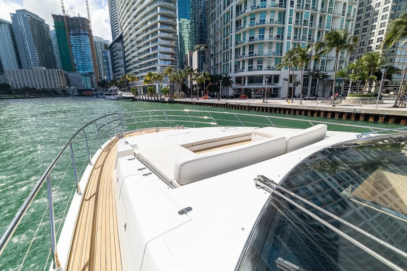 The yacht's foredeck offers a spacious sunbathing area with a stunning urban waterfront backdrop. aboard SABI Yacht for Sale