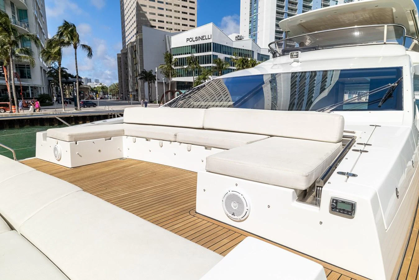 The yacht's aft deck features spacious seating with a beautiful cityscape backdrop. aboard SABI Yacht for Sale