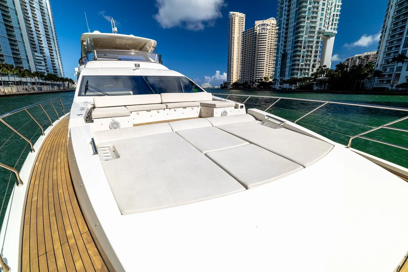 The yacht's foredeck offers spacious sun pads for relaxation with a stunning cityscape backdrop. aboard SABI Yacht for Sale