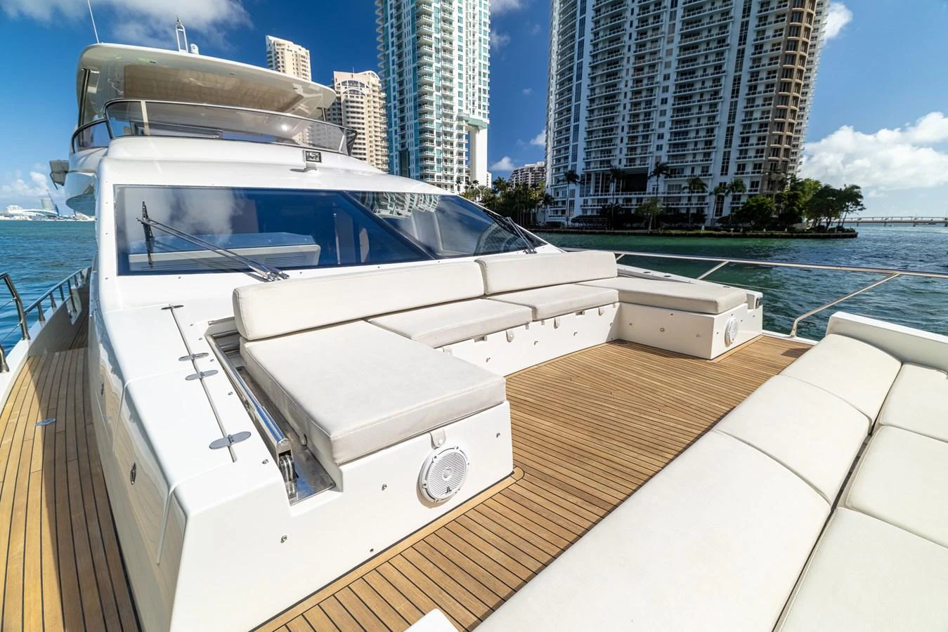 The foredeck features luxurious sun pads and ample seating for relaxation with a stunning cityscape backdrop. aboard SABI Yacht for Sale