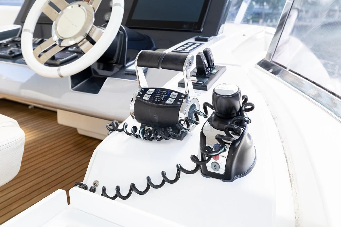The helm station features modern controls and a sleek steering wheel, set against a backdrop of polished wood and high-tech displays. aboard SABI Yacht for Sale