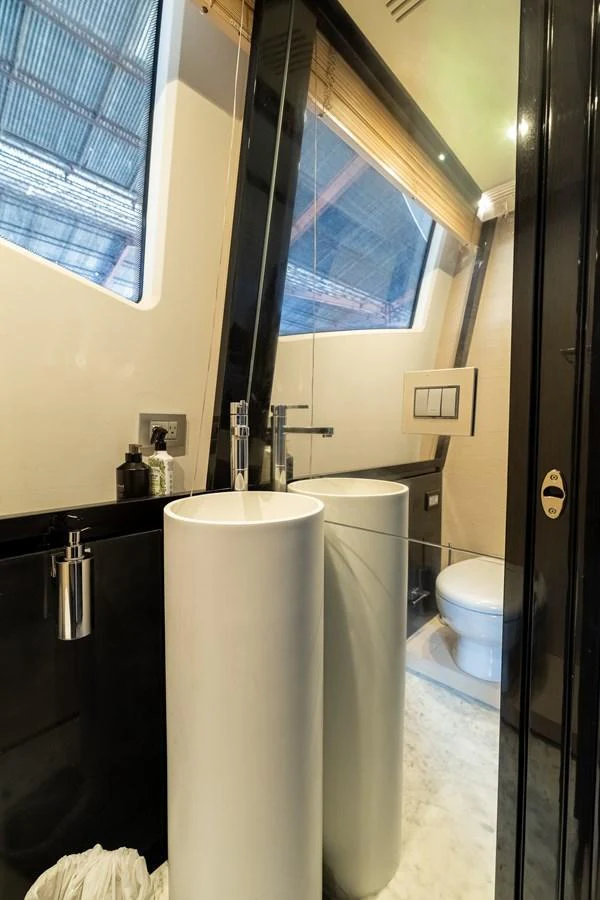 The yacht's bathroom features a modern design with a sleek pedestal sink and contemporary fixtures. aboard SABI Yacht for Sale