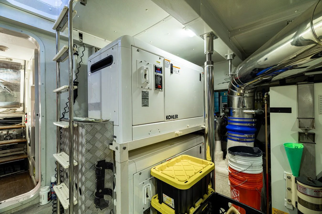 The engine room is equipped with a Kohler generator and various maintenance tools and supplies. aboard SABI Yacht for Sale