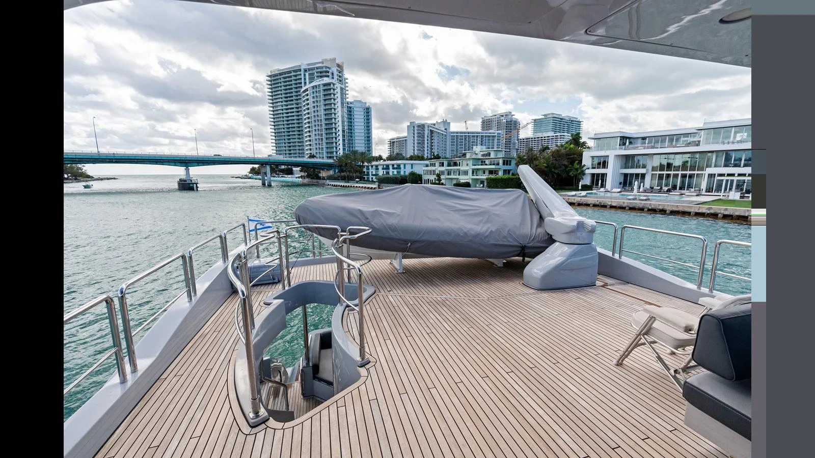 a deck with a large body of water and a city in the background aboard KNOT WOKE Yacht for Sale