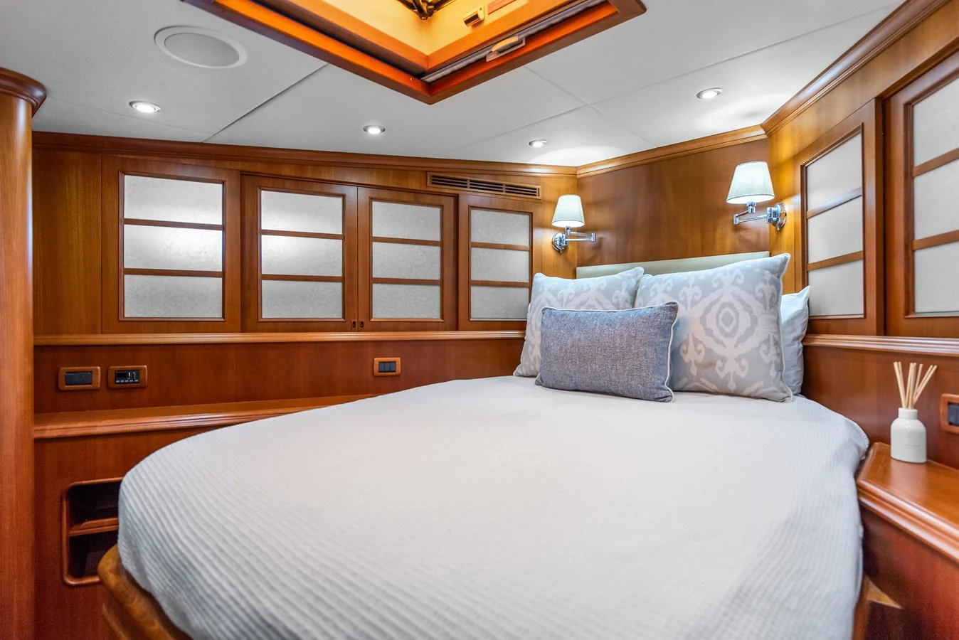 a bed with a white comforter aboard ENCORE Yacht for Sale