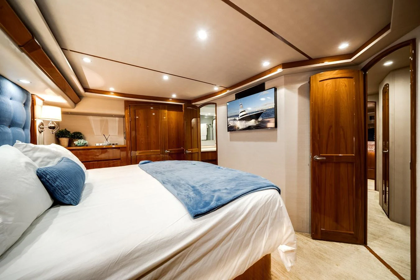 a bedroom with a bed and a wood door aboard EL JEFE Yacht for Sale