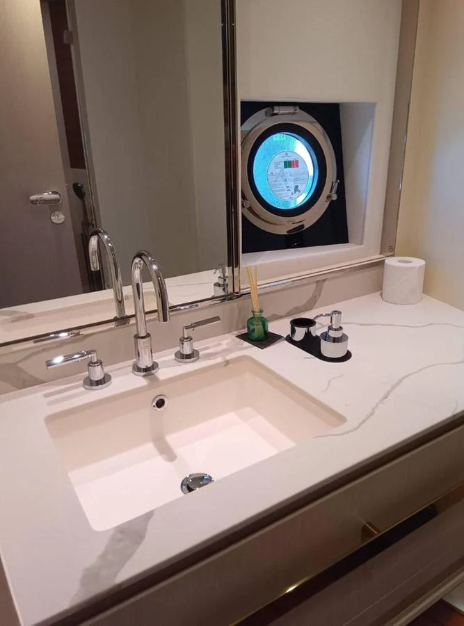 a bathroom sink with a large round mirror aboard ANGEL Yacht for Sale