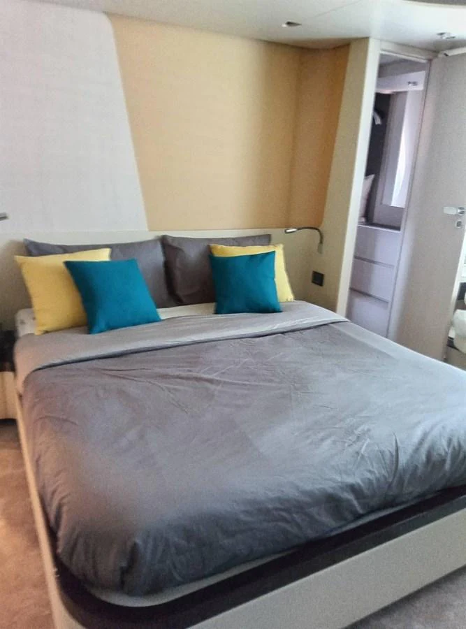 a bed with blue and yellow pillows aboard ANGEL Yacht for Sale