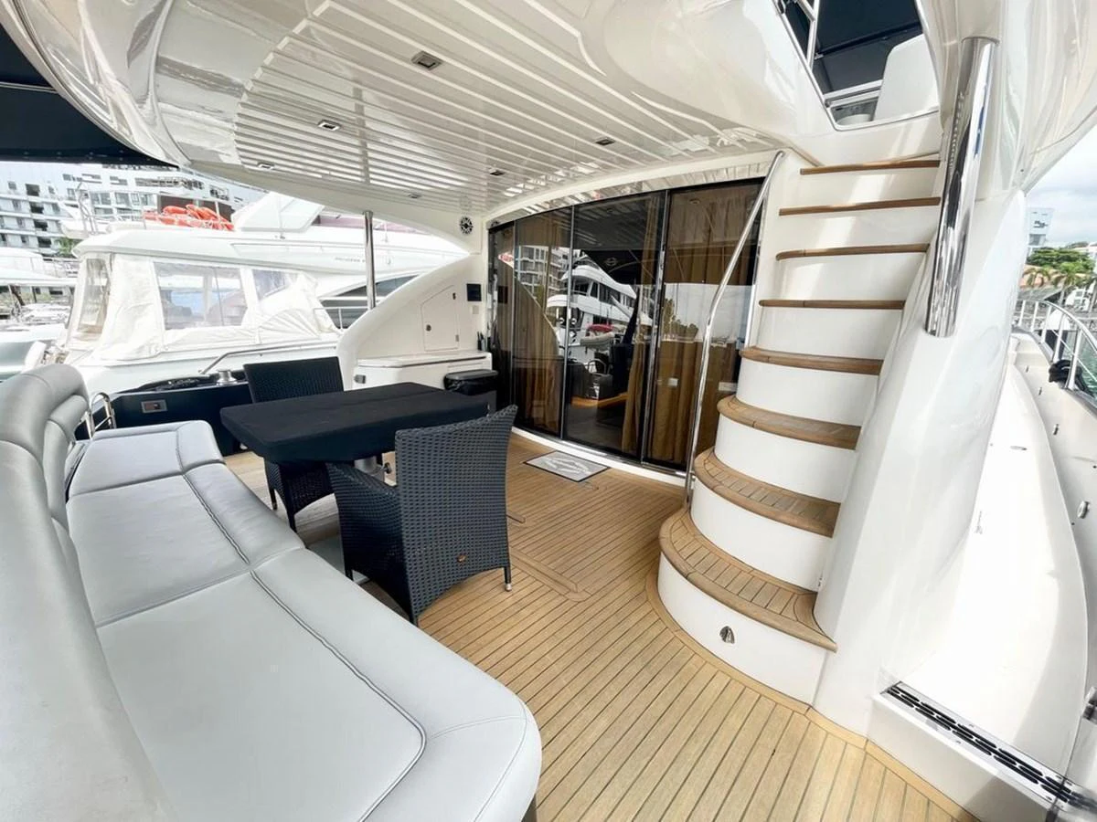 The aft deck features a comfortable seating area with a dining table and easy access to the upper deck via a stylish staircase. aboard ELLYN Yacht for Sale