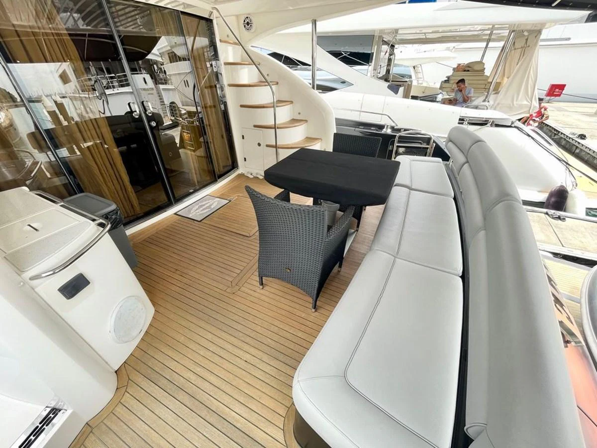 The aft deck features a comfortable seating area with a dining table and access to the upper deck via a spiral staircase. aboard ELLYN Yacht for Sale