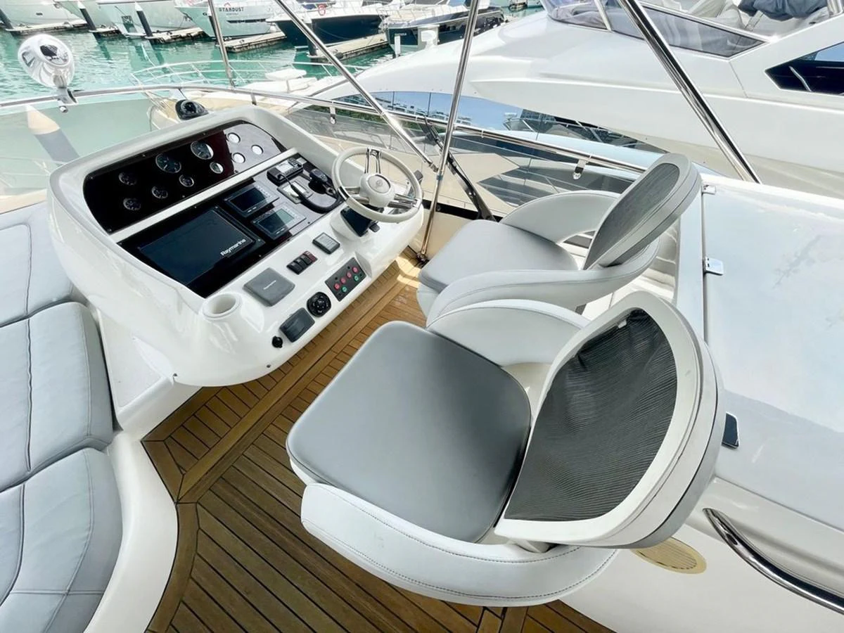 The helm area features a sleek control panel and comfortable seating with a view of the marina. aboard ELLYN Yacht for Sale