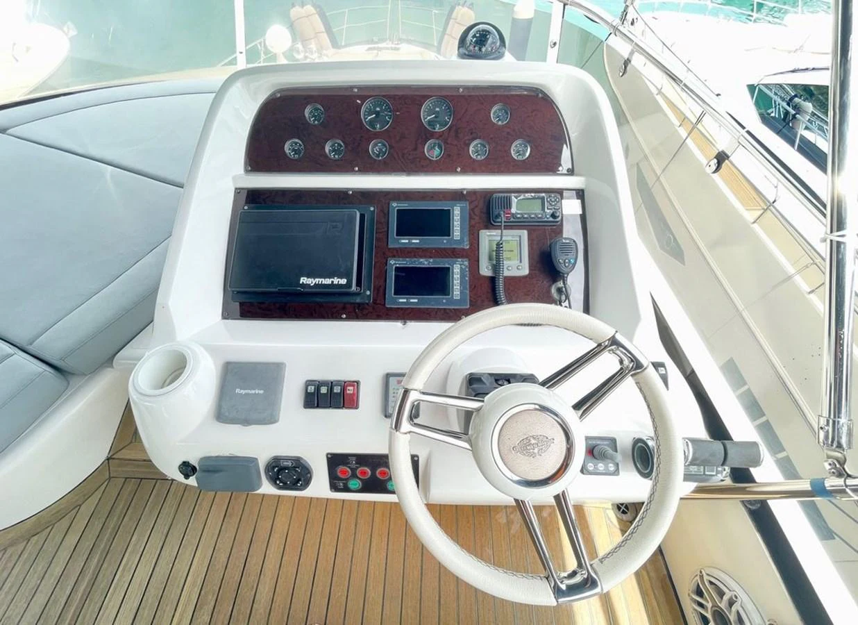 The helm station features modern navigation equipment and a sleek steering wheel. aboard ELLYN Yacht for Sale
