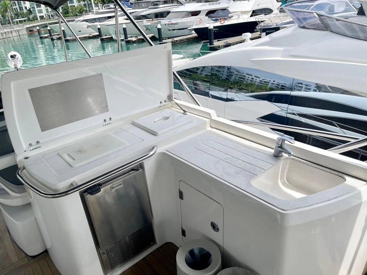The yacht features a sleek wet bar area with a sink and storage, perfect for outdoor entertaining. aboard ELLYN Yacht for Sale