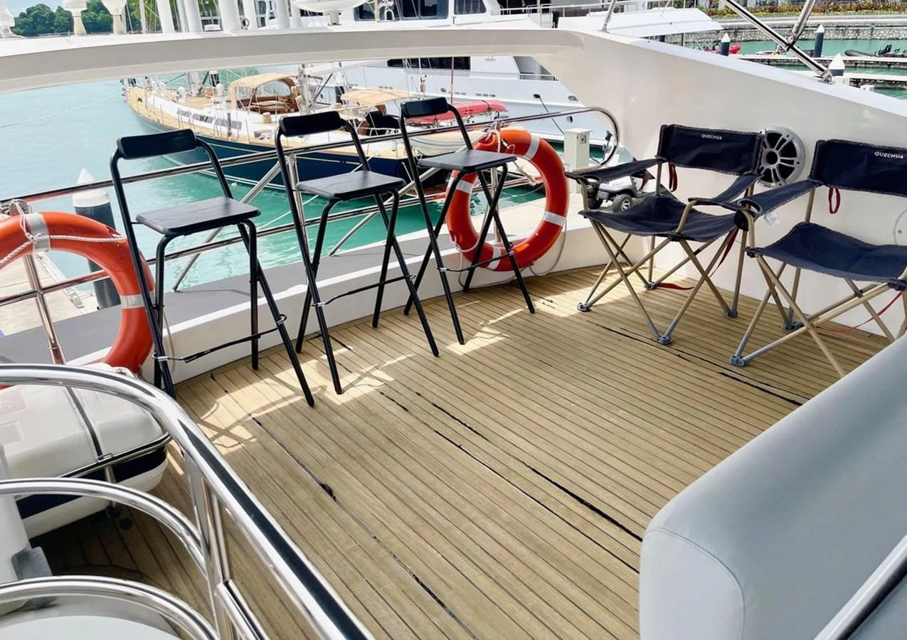 The aft deck features a spacious seating area with folding chairs and safety equipment, perfect for enjoying the view. aboard ELLYN Yacht for Sale