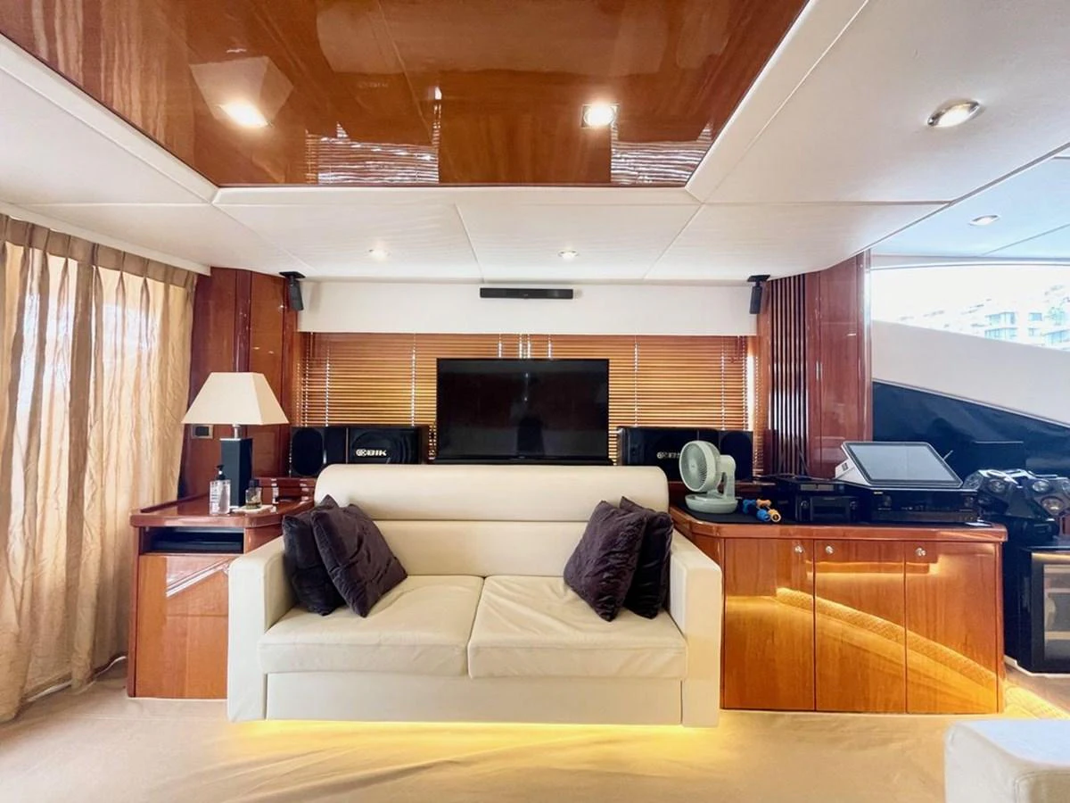The salon features a comfortable seating area with a modern entertainment system and elegant wooden accents. aboard ELLYN Yacht for Sale