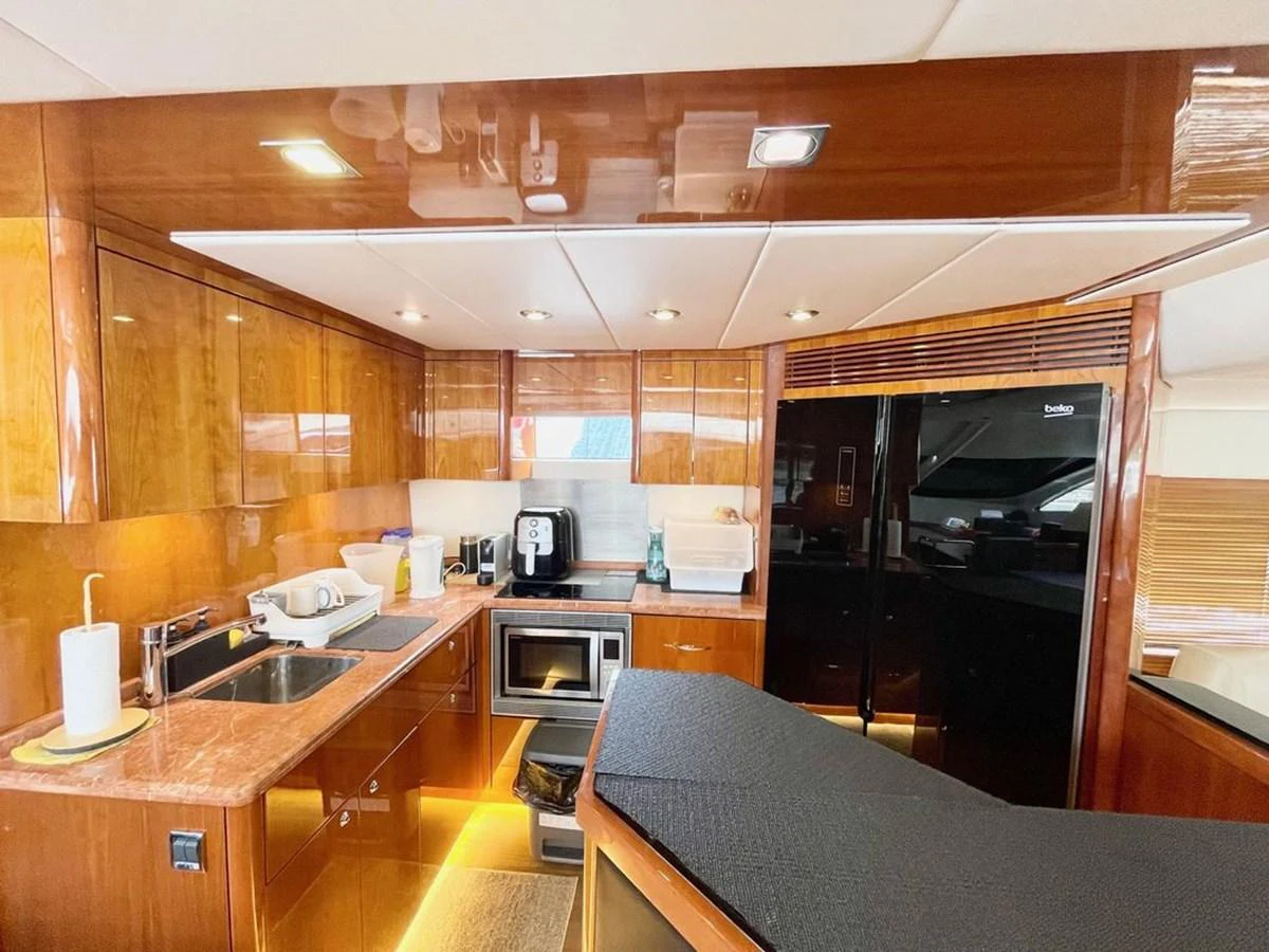 The galley features modern appliances and elegant wood finishes, creating a warm and functional space. aboard ELLYN Yacht for Sale