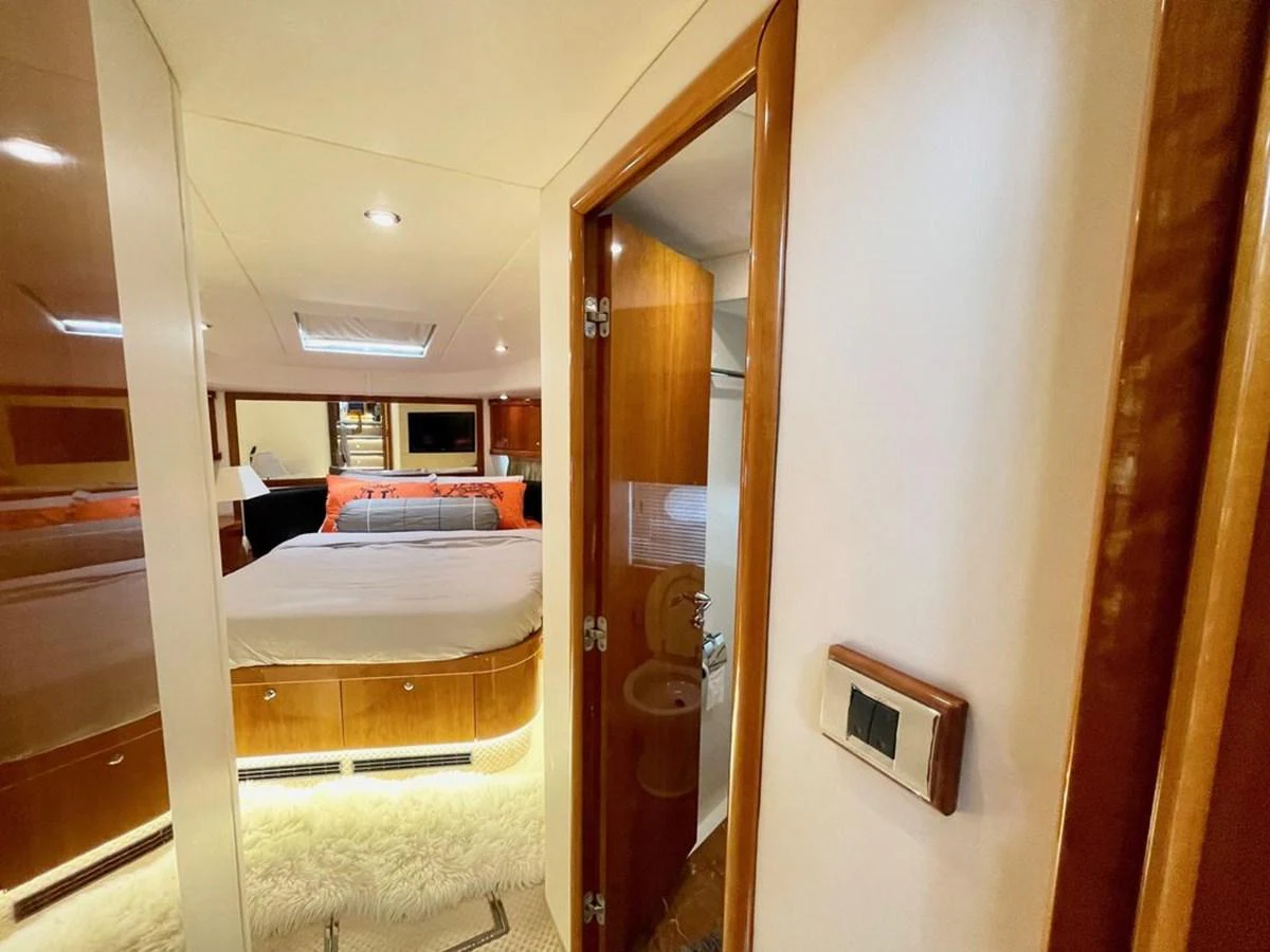 The stateroom features a cozy bed, warm wood finishes, and modern lighting. aboard ELLYN Yacht for Sale