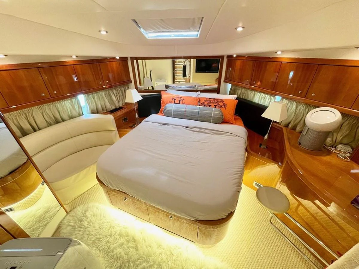 The master stateroom features a luxurious bed, elegant wood finishes, and ample lighting. aboard ELLYN Yacht for Sale