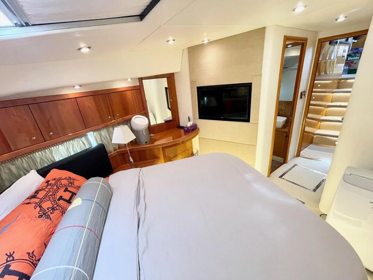 A luxurious stateroom featuring a comfortable bed, wooden cabinetry, and modern lighting. aboard ELLYN Yacht for Sale