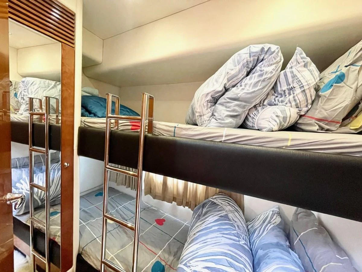 The cozy bunk room features neatly arranged bedding and a practical ladder for easy access. aboard ELLYN Yacht for Sale