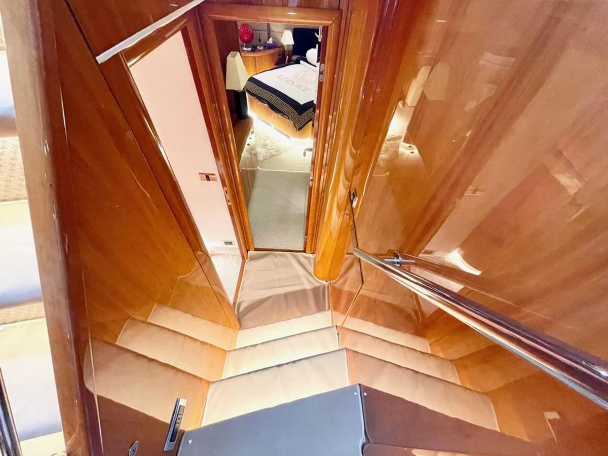 A polished wooden staircase leads down to a cozy cabin area. aboard ELLYN Yacht for Sale