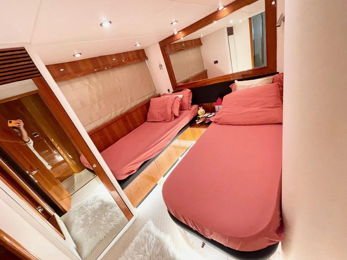 The guest stateroom features twin beds with elegant bedding and warm wood accents. aboard ELLYN Yacht for Sale