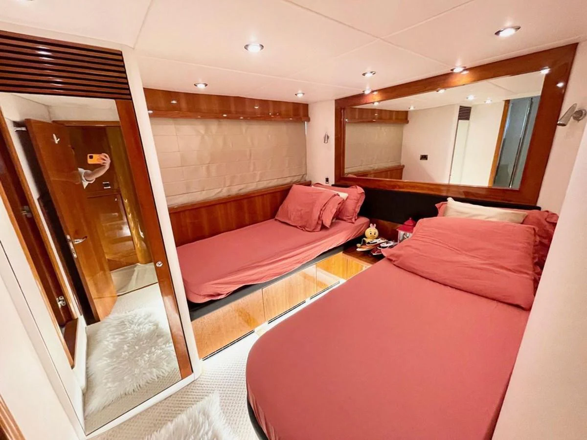 The guest stateroom features twin beds with plush bedding and warm wood accents. aboard ELLYN Yacht for Sale