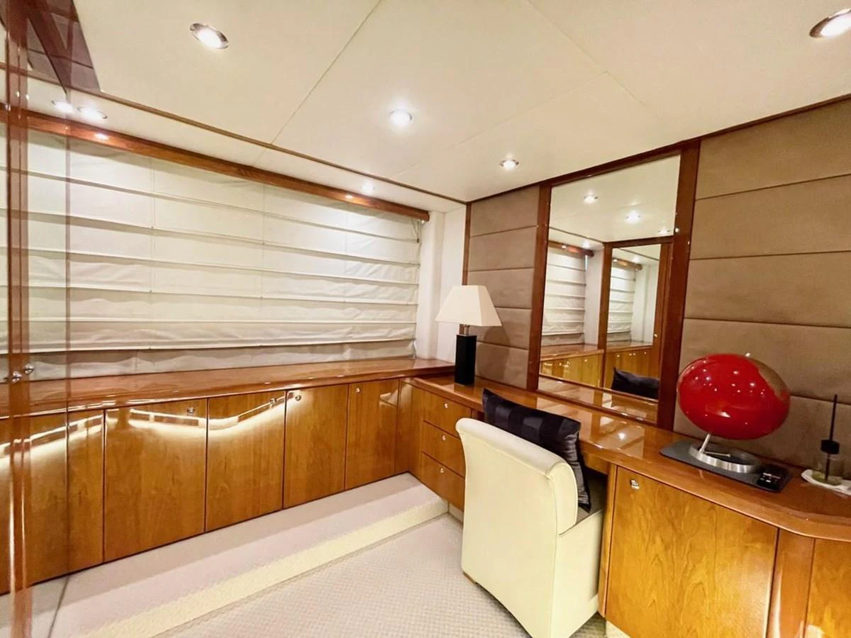 The yacht's office features elegant wood cabinetry, a comfortable chair, and modern decor. aboard ELLYN Yacht for Sale