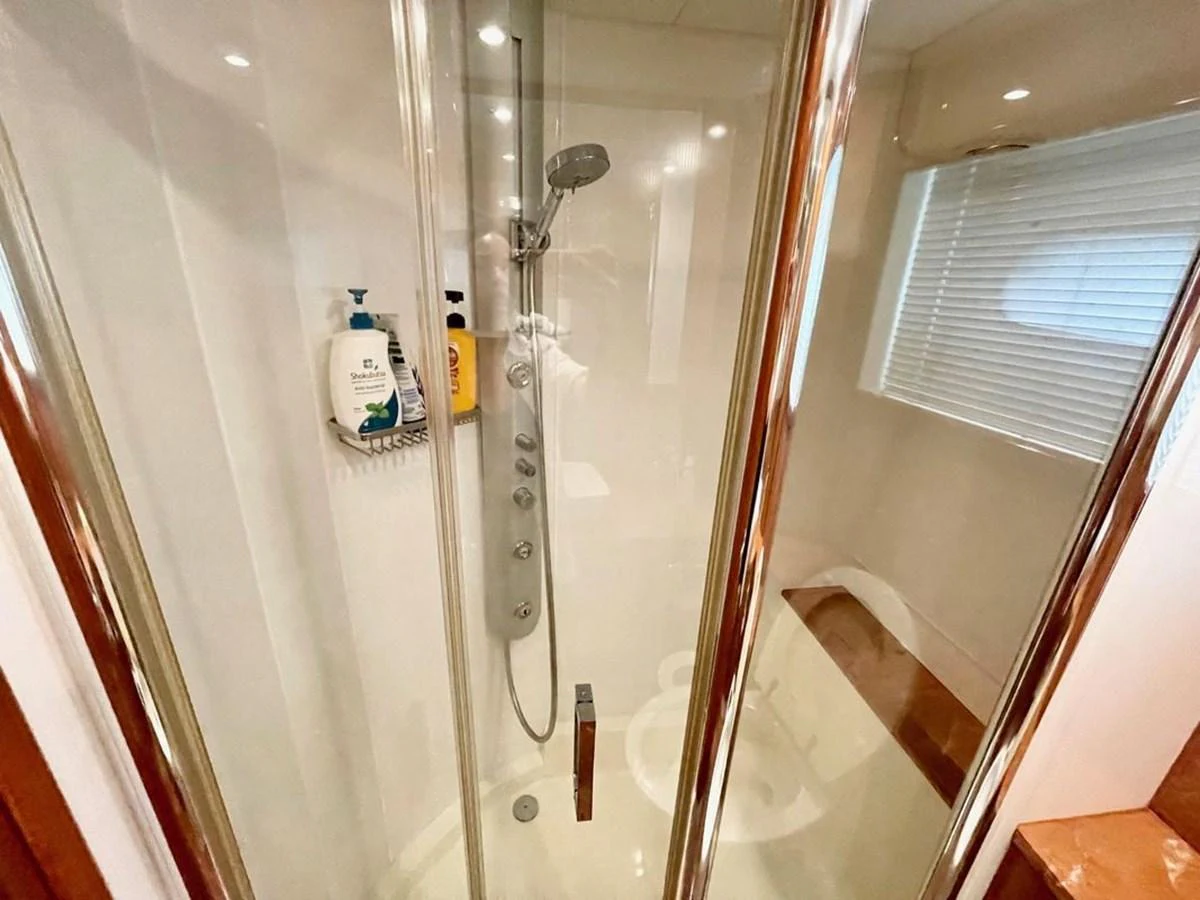 A modern yacht bathroom featuring a glass-enclosed shower with sleek fixtures. aboard ELLYN Yacht for Sale