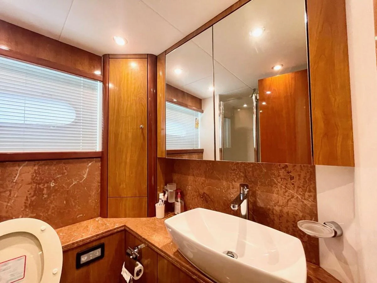 The yacht's bathroom features elegant wood paneling and a modern sink. aboard ELLYN Yacht for Sale