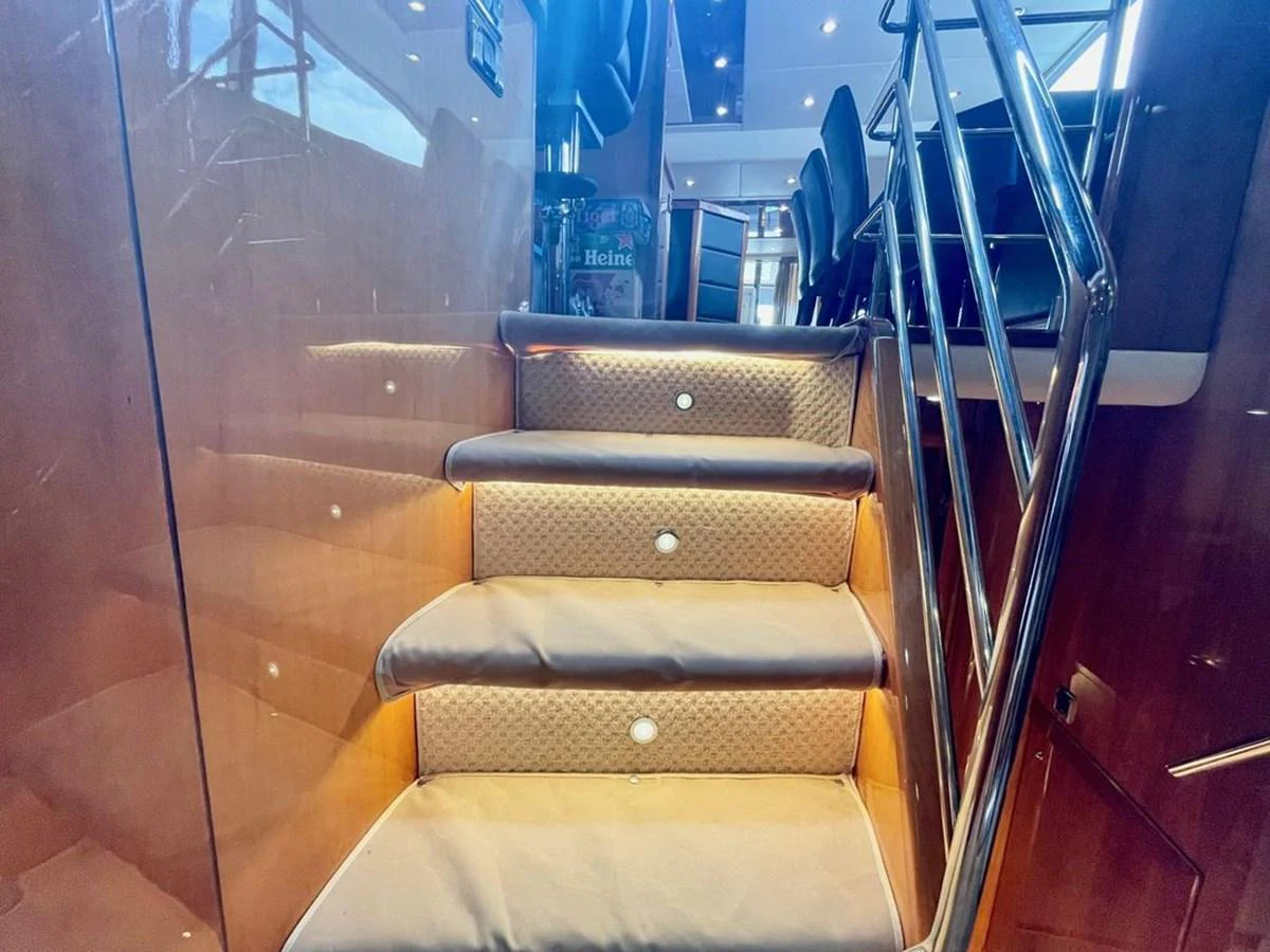 A luxurious staircase with plush carpeting and ambient lighting leads to the upper deck. aboard ELLYN Yacht for Sale