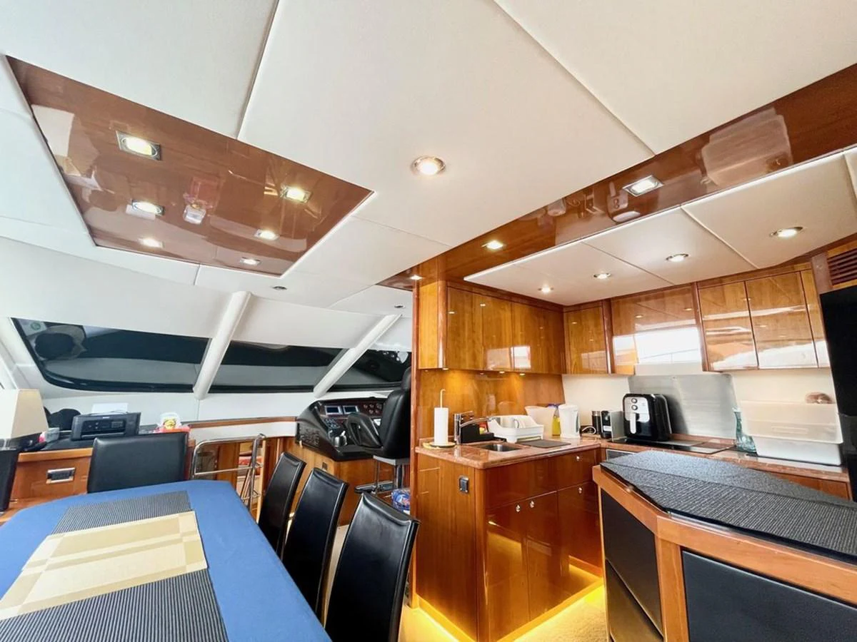 The galley features modern amenities and a sleek design with warm wood finishes. aboard ELLYN Yacht for Sale