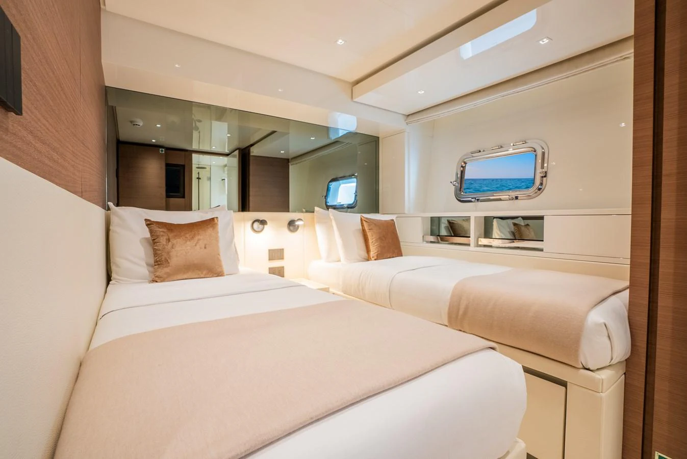 The guest stateroom features two comfortable twin beds with elegant bedding and a window offering a view of the sea. aboard ASTRIMARE Yacht for Sale