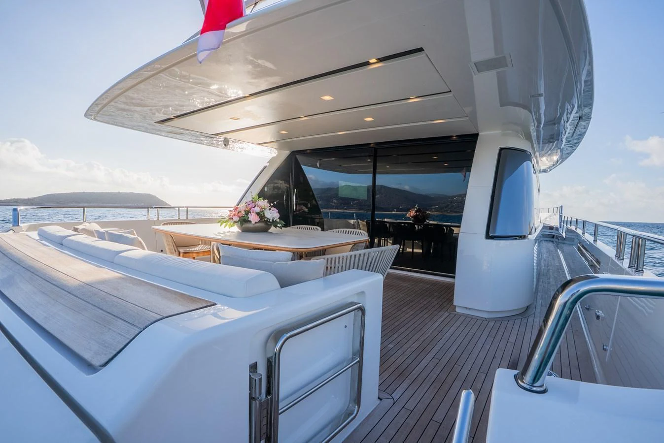 The aft deck features a spacious seating area with a dining table, perfect for enjoying meals with a view of the sea. aboard ASTRIMARE Yacht for Sale