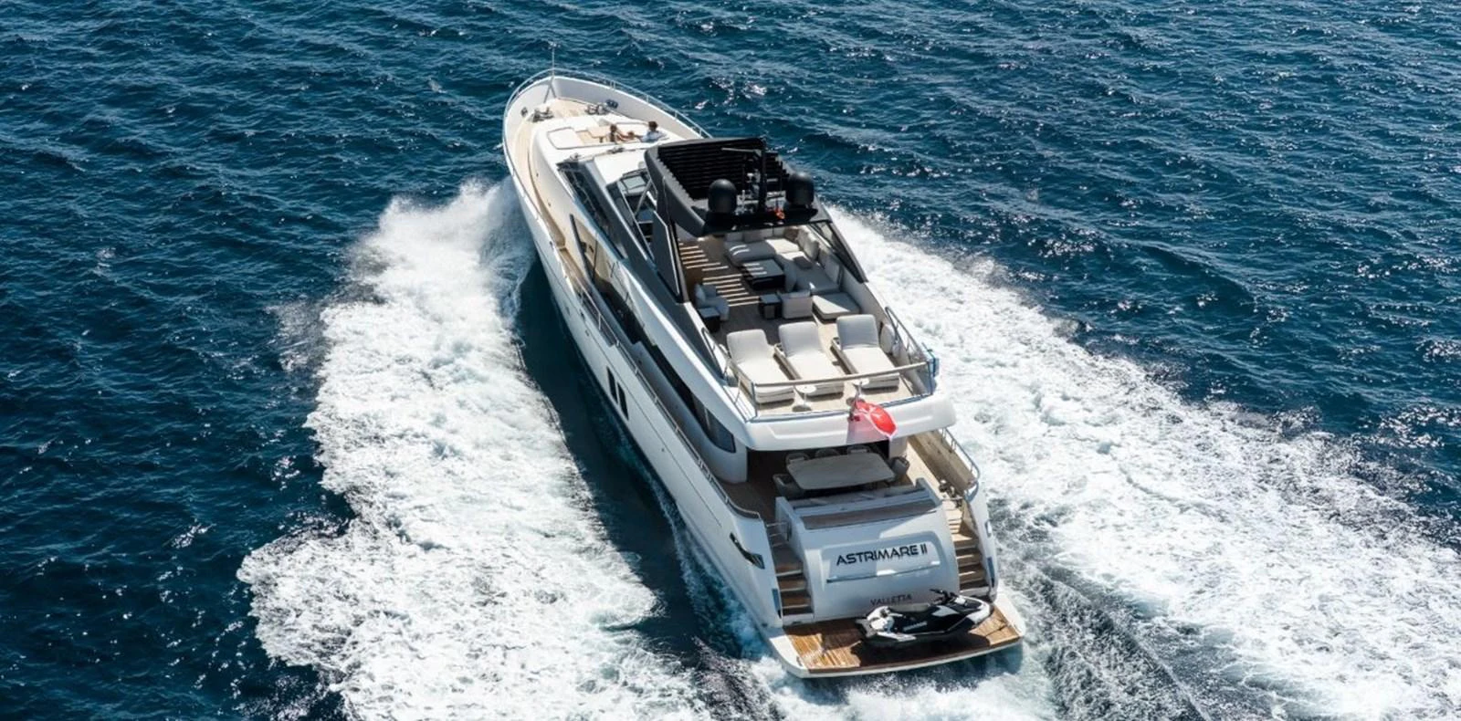 A luxurious yacht cruises through the open sea, showcasing its elegant design and spacious deck areas. aboard ASTRIMARE Yacht for Sale