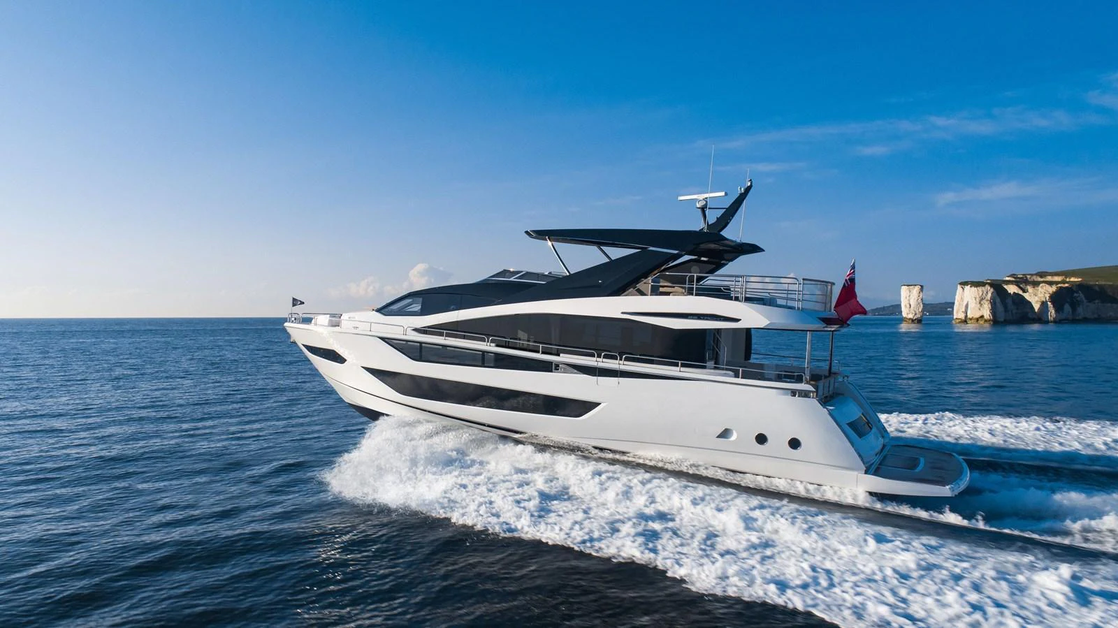 A sleek and modern yacht cruising swiftly on open waters under a clear blue sky. aboard SU Yacht for Sale