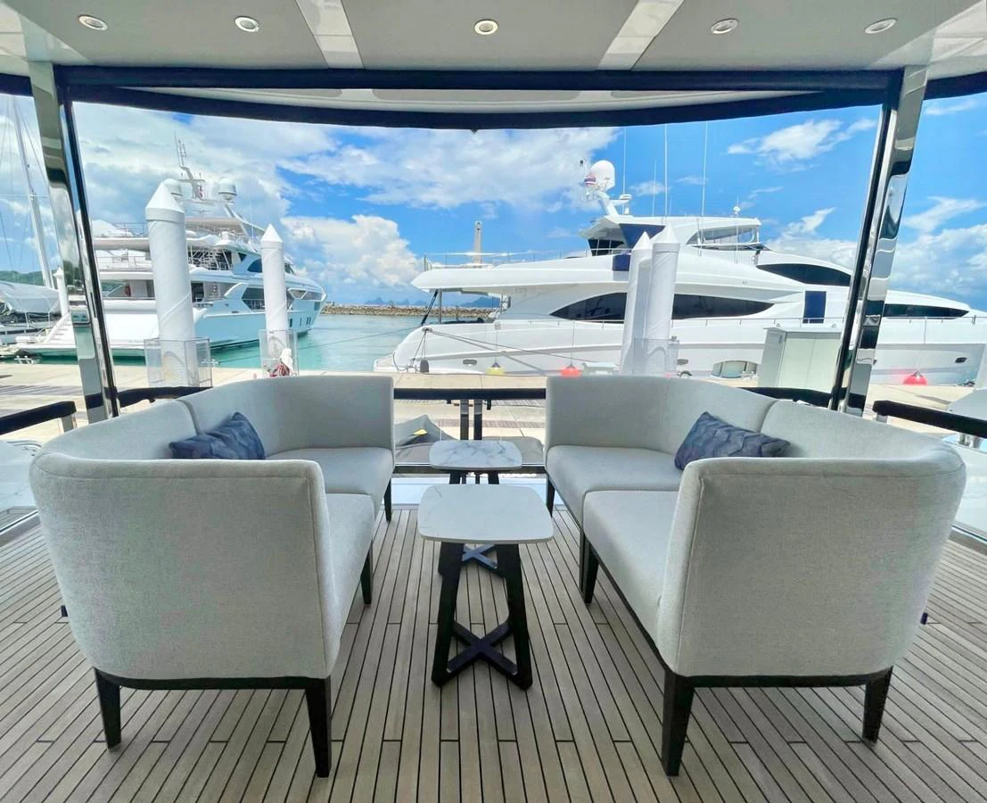 The aft deck features a stylish seating area with plush sofas and a central table, offering a perfect spot for relaxation with a view of the marina. aboard SU Yacht for Sale