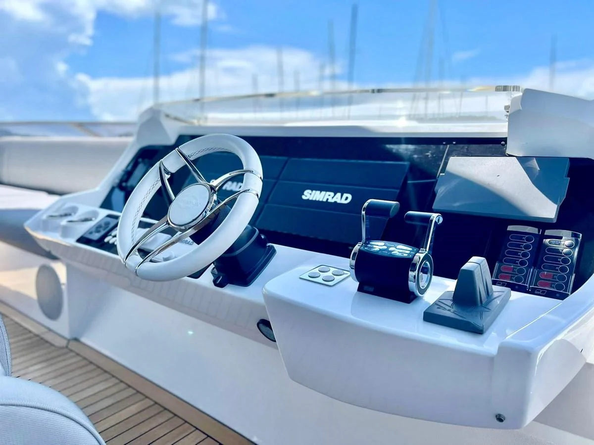 The helm station features modern navigation equipment and a sleek steering wheel. aboard SU Yacht for Sale