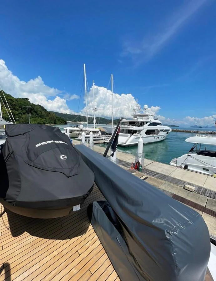 The image showcases a docked yacht with its tender and jet ski covered and secured on the deck. aboard SU Yacht for Sale