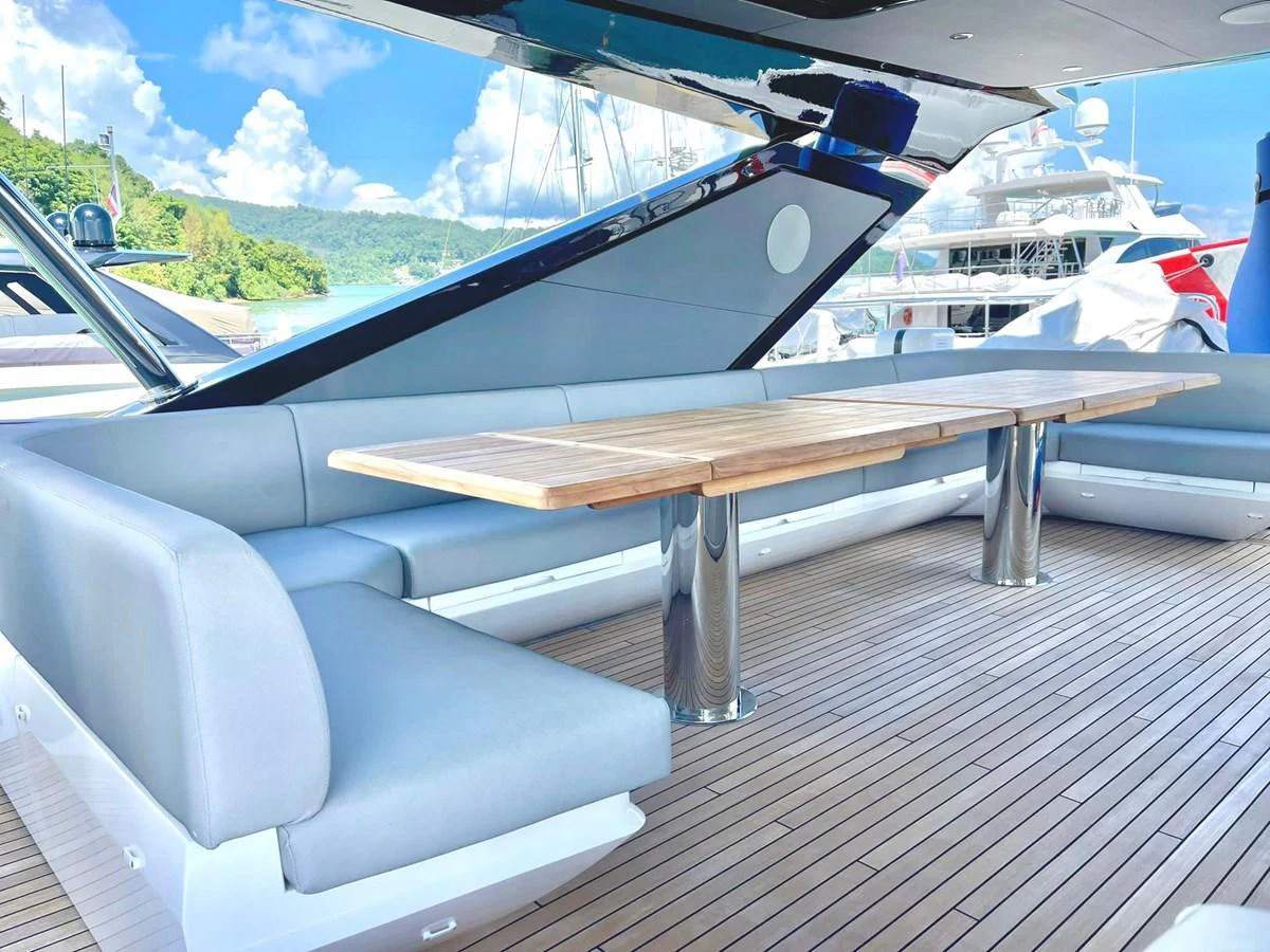 The aft deck features a spacious seating area with a large wooden dining table, perfect for alfresco dining. aboard SU Yacht for Sale