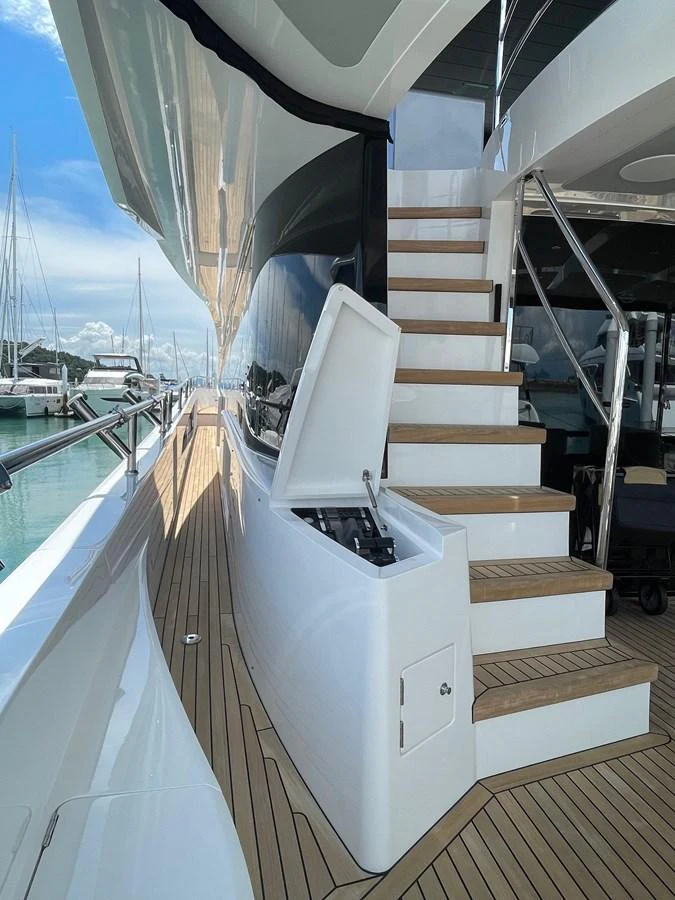 The image showcases a sleek side deck with a staircase leading to the upper level, featuring a storage compartment. aboard SU Yacht for Sale