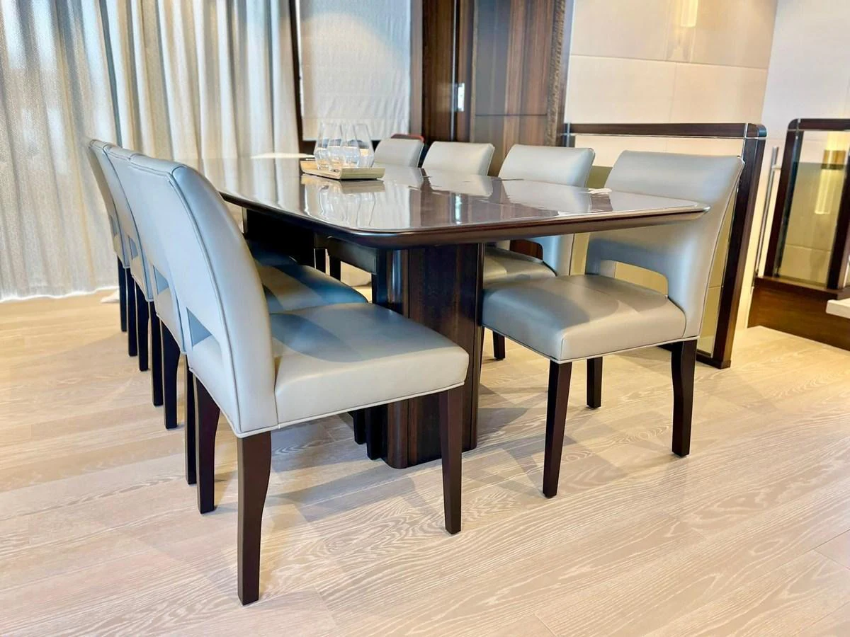 The yacht's dining area features a sleek table surrounded by comfortable, modern chairs. aboard SU Yacht for Sale