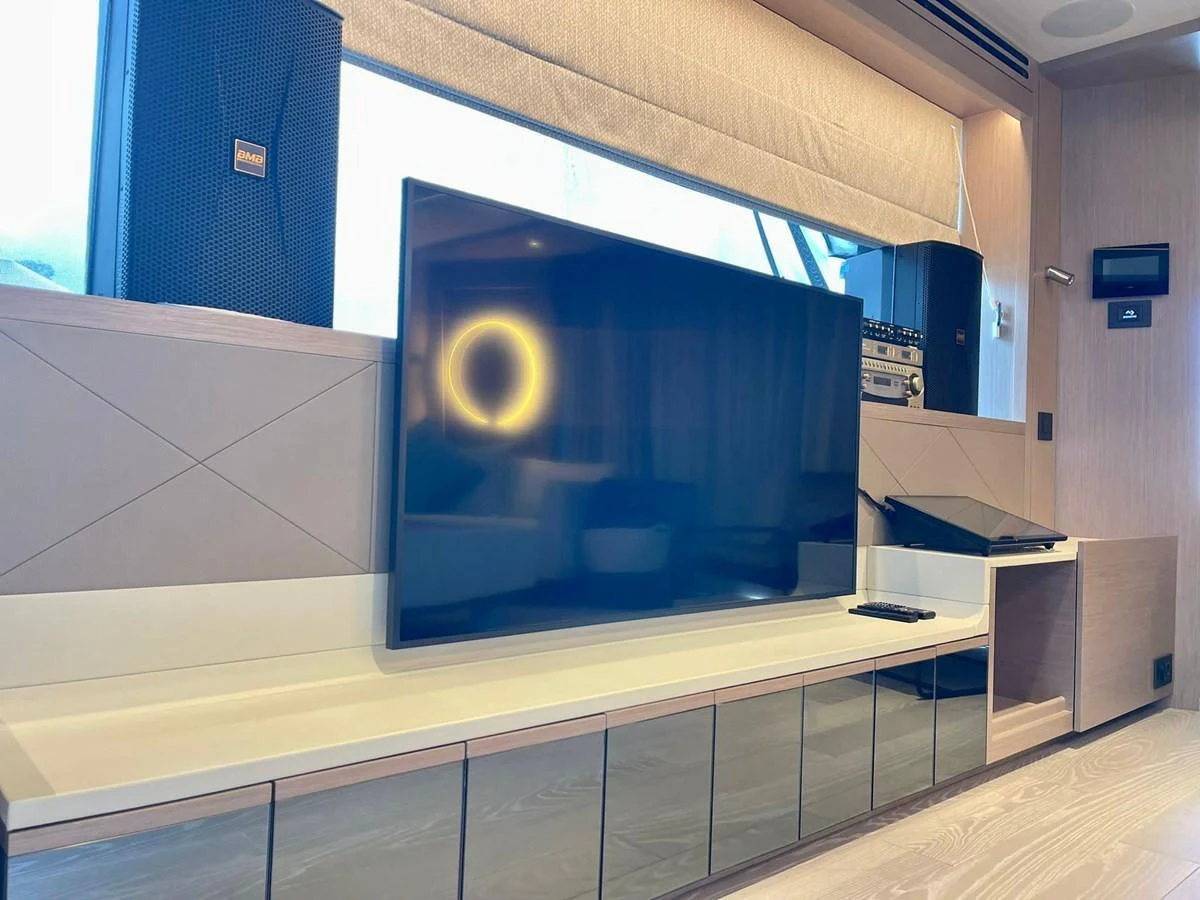 The yacht's interior features a modern entertainment area with a large flat-screen TV and sleek cabinetry. aboard SU Yacht for Sale