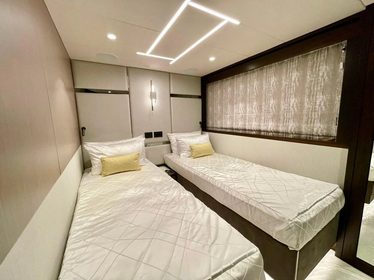 The twin stateroom offers a cozy and modern sleeping area with two single beds and elegant lighting. aboard SU Yacht for Sale