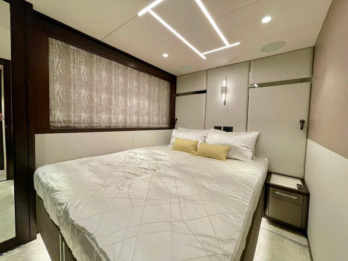 The stateroom features a luxurious bed with modern lighting and elegant decor. aboard SU Yacht for Sale