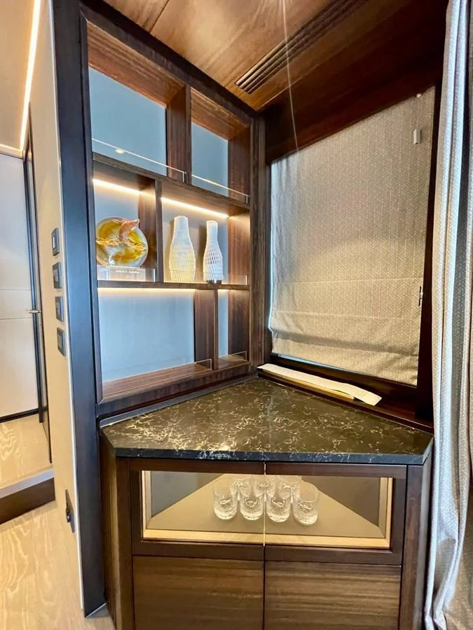 A stylish interior corner features a marble countertop and elegant glassware display. aboard SU Yacht for Sale