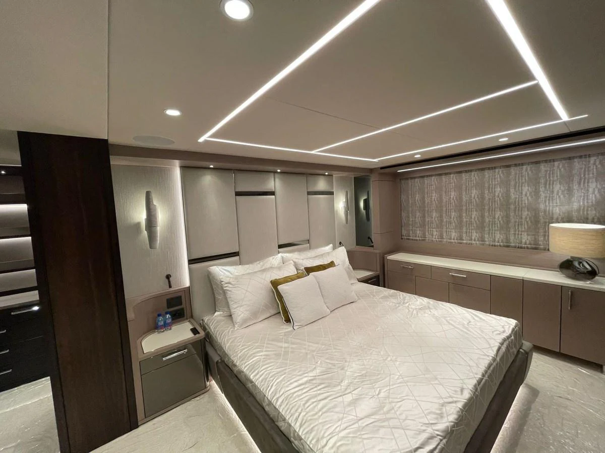 The master stateroom features a luxurious bed with modern lighting and ample storage. aboard SU Yacht for Sale