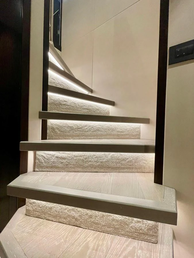 A modern, well-lit staircase with sleek design elements. aboard SU Yacht for Sale