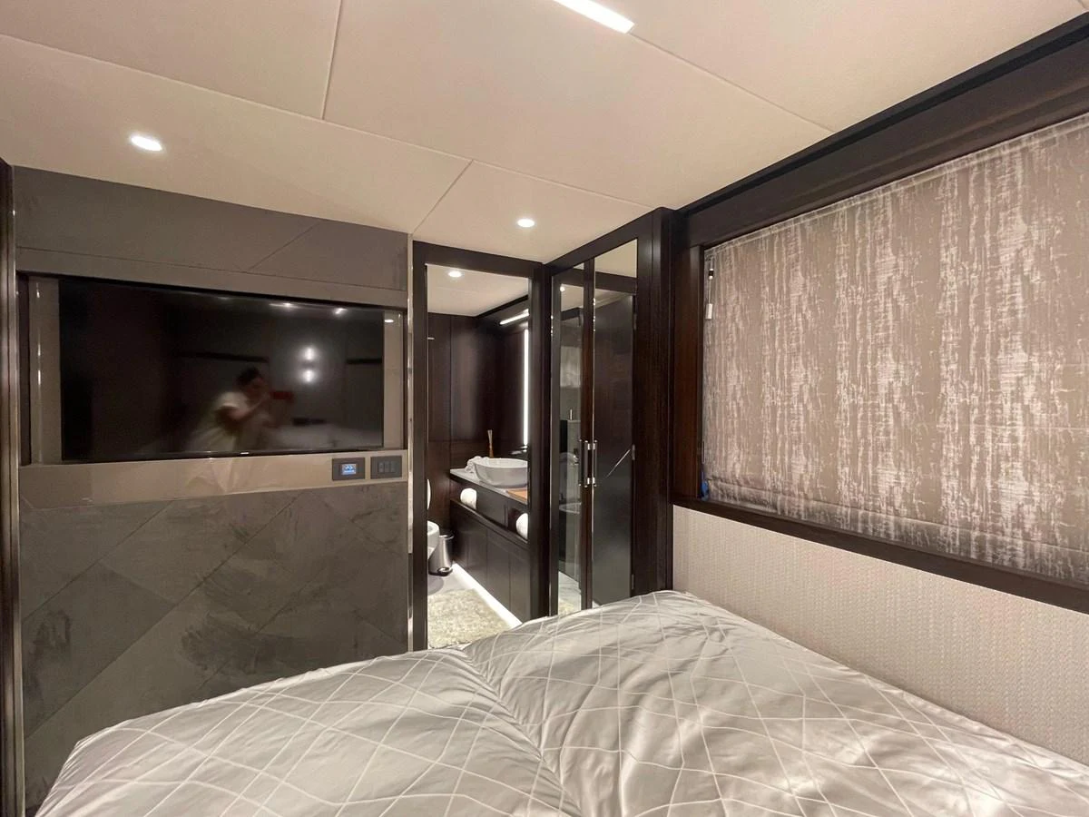 A luxurious stateroom featuring a large bed, modern decor, and an ensuite bathroom. aboard SU Yacht for Sale